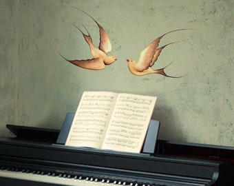 May include: A black digital piano with a sheet music stand and two stylized brown birds painted on a light green wall behind the piano.