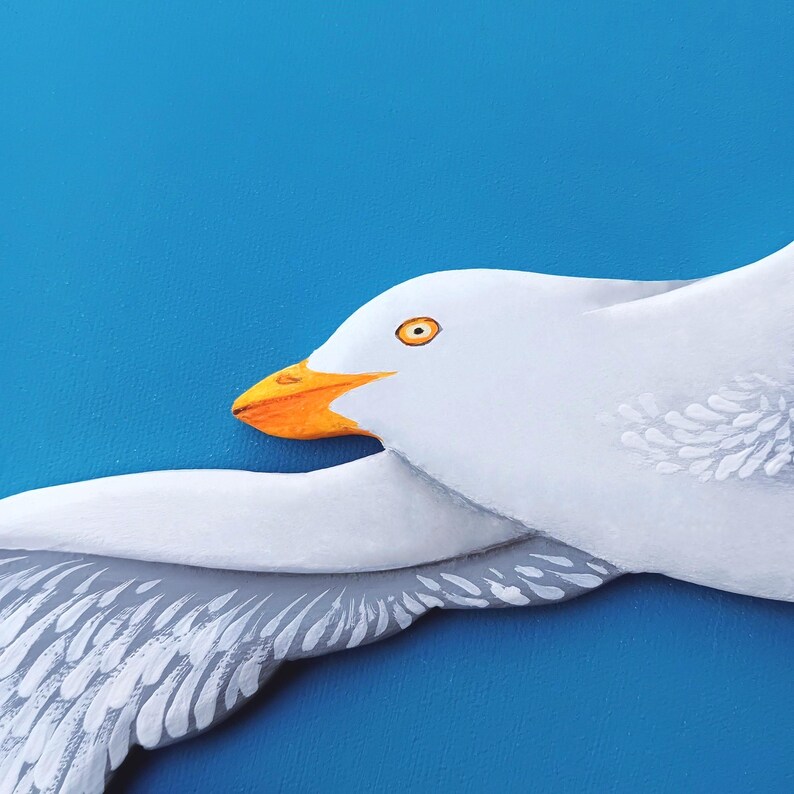 Detailed texture of a handmade wooden seagull – smooth painted surface and carved detail