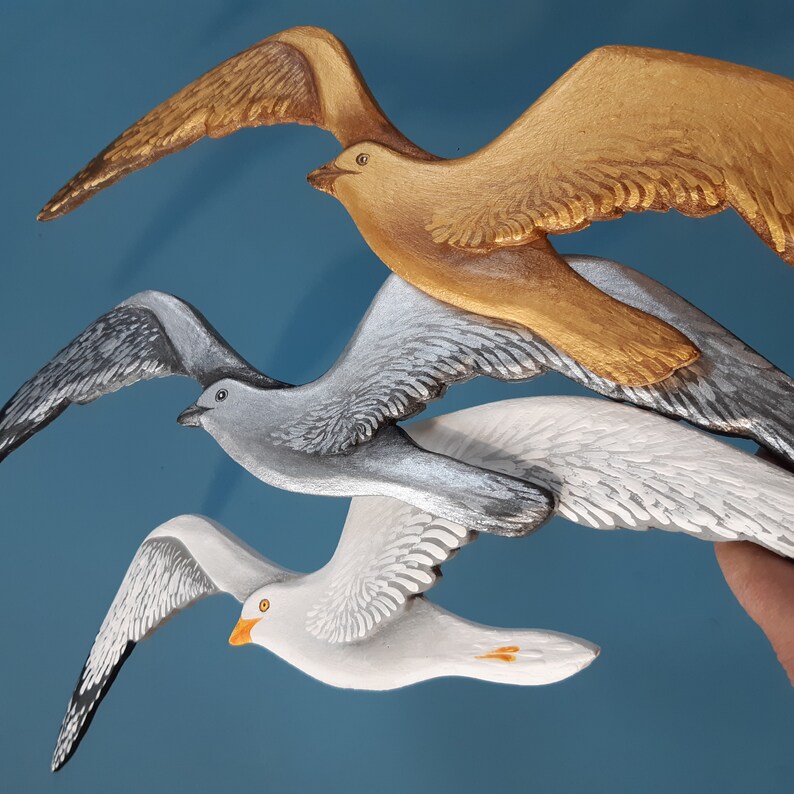 Trio of wooden seagulls in white, silver, and gold colors – modern coastal wall art