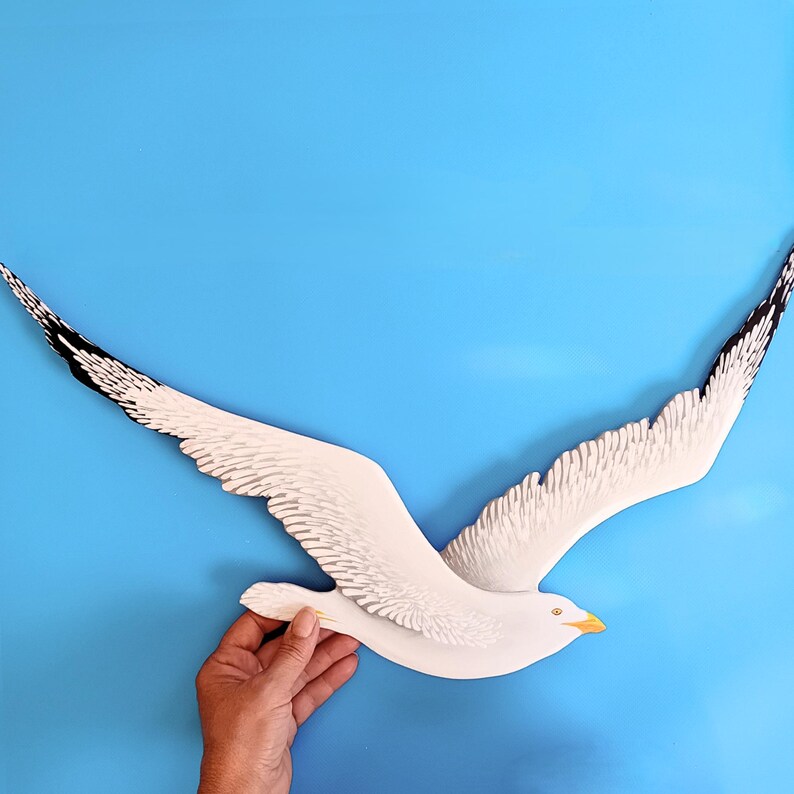 Hand carved and painted wooden seagull, part of a flock of seagulls wall art