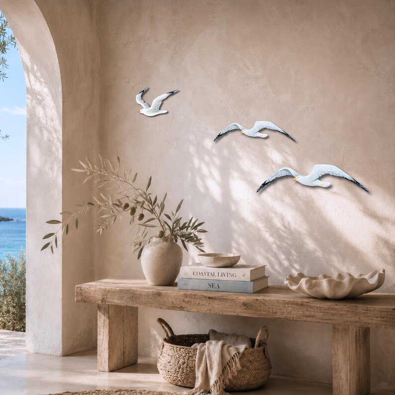 Three flying seagulls placed at a coastal entrance above a wooden bench.