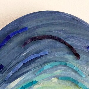 May include: A blue, green, and white painted wooden half-circle with blue and purple mosaic tiles arranged in a curved pattern.