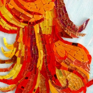May include: Close-up of a mosaic artwork featuring a fiery orange, red, and yellow design. The mosaic is made of small, irregular pieces of glass, creating a textured and vibrant effect.