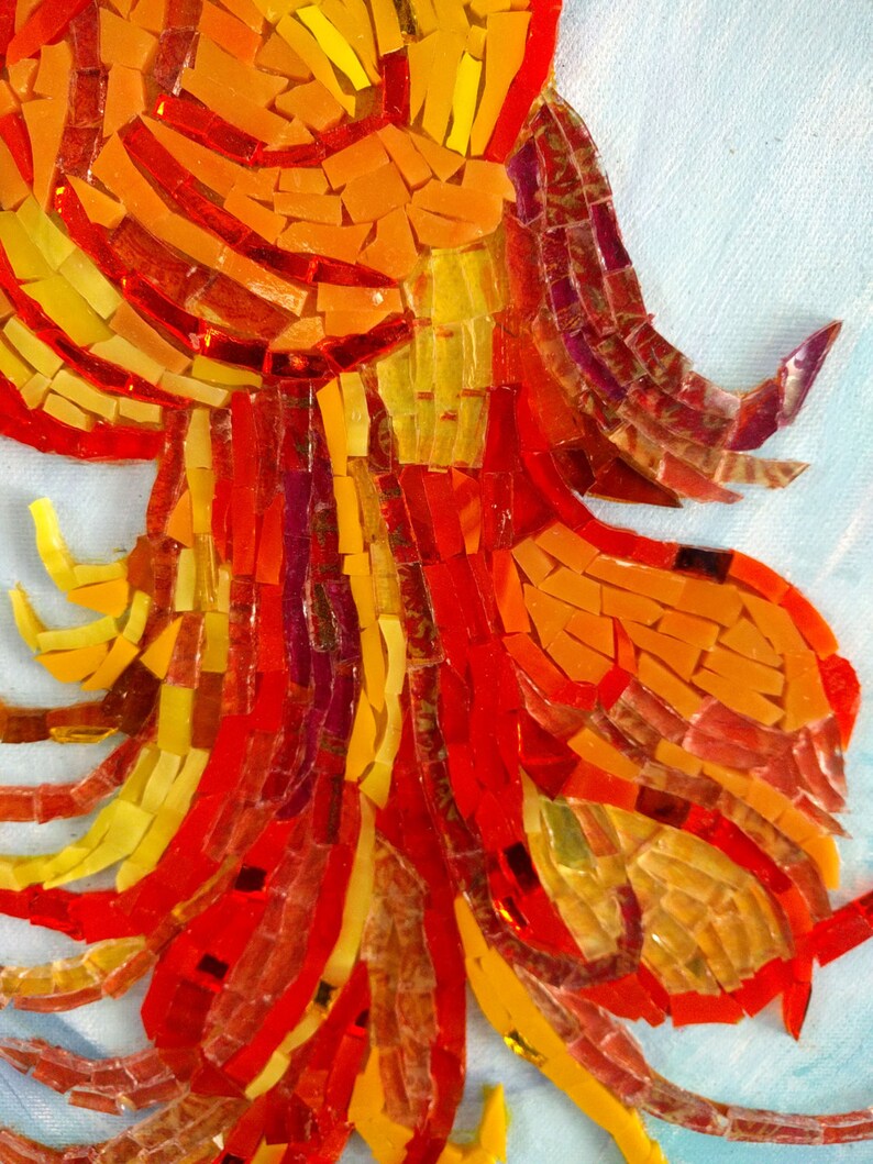 May include: Close-up of a mosaic artwork featuring a fiery orange, red, and yellow design. The mosaic is made of small, irregular pieces of glass, creating a textured and vibrant effect.