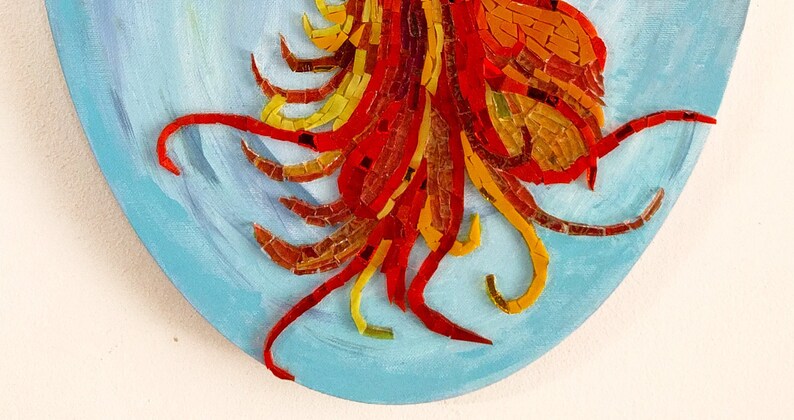 May include: A close-up of a mosaic artwork featuring a red, orange, and yellow design. The mosaic is set against a blue background.