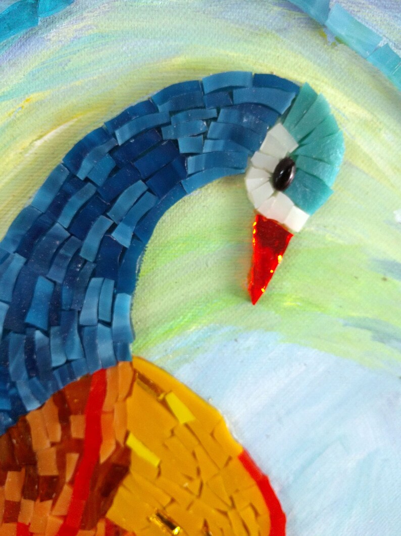 May include: Close-up of a mosaic peacock with blue, red, and yellow glass tiles. The peacock's head is turned to the side, and its eye is visible.