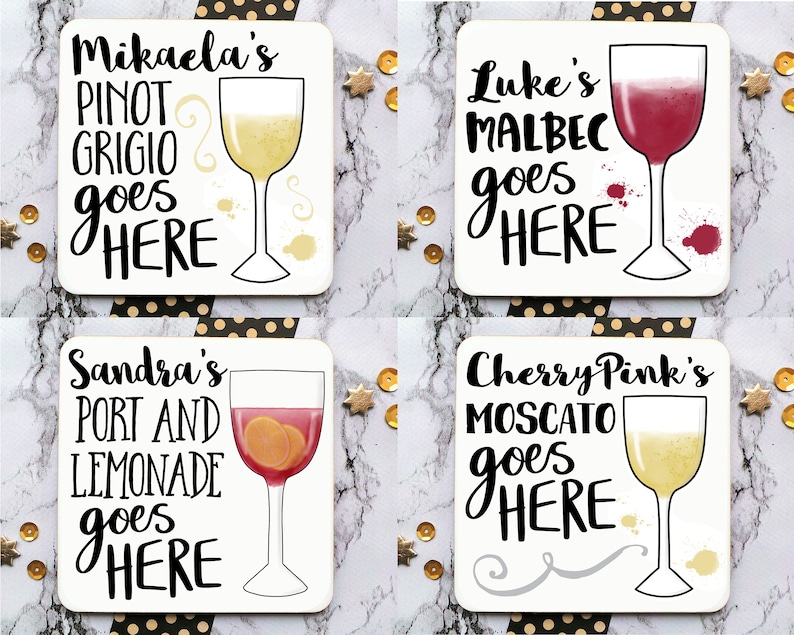 Puede incluir: Cuatro posavasos cuadrados blancos con letras negras e ilustraciones de copas de vino. Los posavasos presentan el texto "Mikaela's Pinot Grigio goes HERE", "Luke's Malbec goes HERE", "Sandra's Port and Lemonade goes HERE", y "Cherry Pink's Moscato goes HERE".