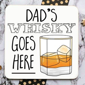 May include: White coaster with black text that reads "Dad's Whisky Goes Here" with a line underneath the text. A black line drawing of a glass of whiskey with ice cubes is to the right of the text.