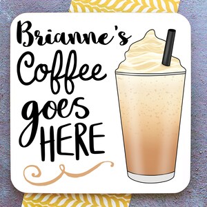 Op de afbeelding: Witte vierkante onderzetter met zwarte tekst die "Brianne's Coffee goes HERE" luidt, met een decoratieve krul eronder. Aan de rechterkant van de onderzetter staat een cartoonafbeelding van een ijskoffie met slagroom en een rietje.