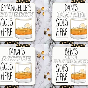 May include: Four white square coasters with black text and illustrations of glasses of alcohol. The coasters say "Emanuel's Bourbon Goes Here", "Tara's Scotch Goes Here", "Dan's Dram Goes Here", and "Ben's Old Fashioned Goes Here".
