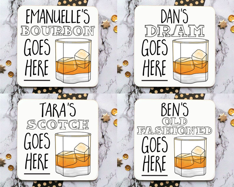 May include: Four white square coasters with black text and illustrations of glasses of alcohol. The coasters say "Emanuel's Bourbon Goes Here", "Tara's Scotch Goes Here", "Dan's Dram Goes Here", and "Ben's Old Fashioned Goes Here".
