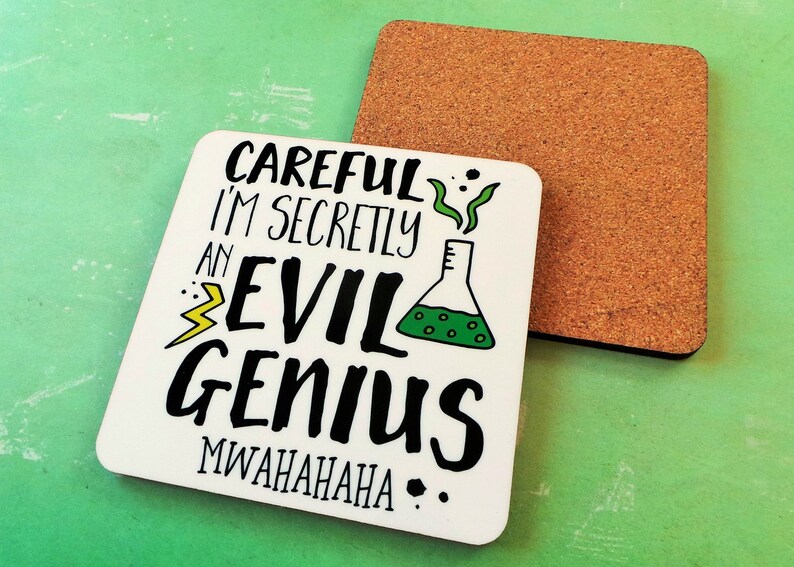 Puede incluir: Posavasos blanco con texto negro que dice "Careful I'm secretly an evil genius MWAHAHAHAHA." El texto est&aacute; rodeado por un dibujo animado verde y amarillo de un vaso de precipitados con l&iacute;quido verde y humo.