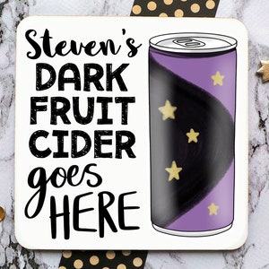 May include: A white coaster with black text that reads "Steven's DARK FRUIT CIDER goes HERE". A purple can with black and gold stars is to the right of the text.