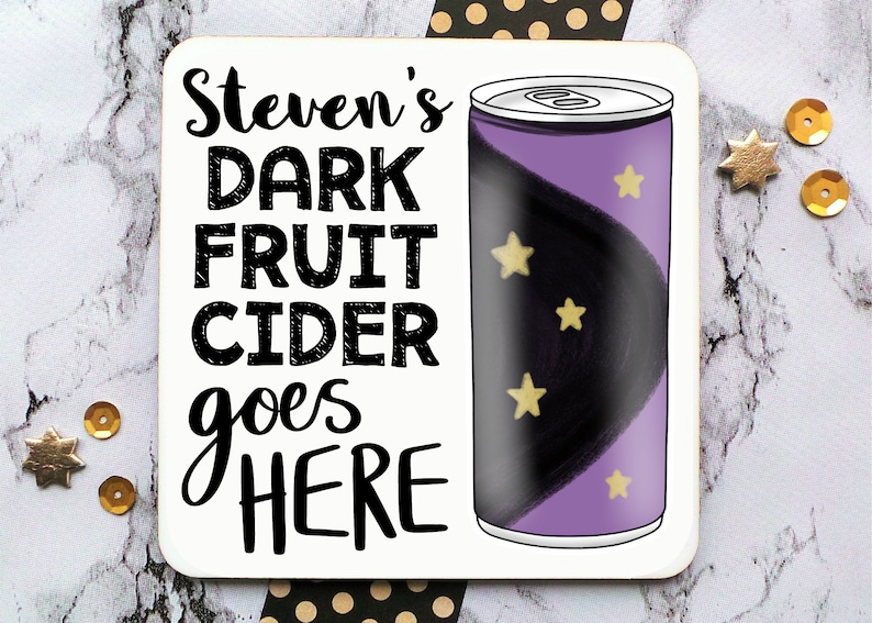 May include: A white coaster with black text that reads "Steven's DARK FRUIT CIDER goes HERE". A purple can with black and gold stars is to the right of the text.
