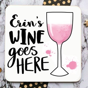 Puede incluir: Posavasos blanco con texto negro que dice "Erin's Wine goes here" y una copa de vino rosa con salpicaduras de pintura rosa.