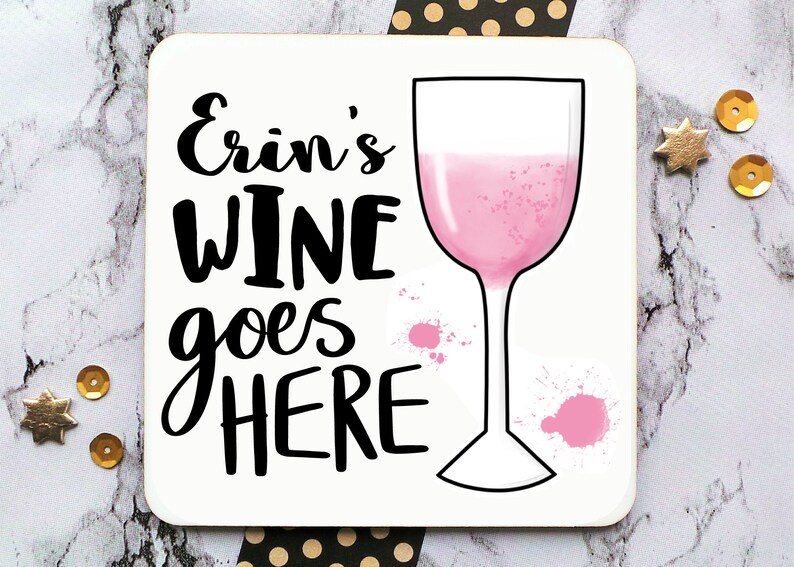 Puede incluir: Posavasos blanco con texto negro que dice "Erin's Wine goes here" y una copa de vino rosa con salpicaduras de pintura rosa.