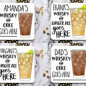 May include: Four white square coasters with black lettering and illustrations of glasses of whiskey and coke or ginger ale. The coasters feature personalized names like "Amanda's Whiskey and Coke Goes Here", "Frank's Whiskey and Ginger Ale Goes Here", "Margaret's Whiskey and Ginger Ale Goes Here", and "Dad's Whiskey and Coke Goes Here".