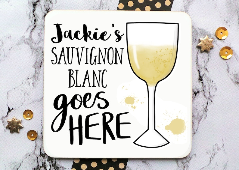 Puede incluir: Posavasos blanco con texto negro que dice "Jackie's Sauvignon Blanc goes here" y un contorno negro de una copa de vino llena de l&iacute;quido amarillo.