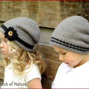 May include: Two children wearing gray knit hats with black trim. The girl's hat has a black flower with a brown button in the center. The boy's hat has two black stripes around the brim.  Stitch of Nature.