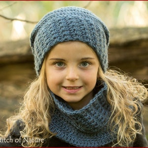Puede incluir: Una persona joven con un gorro y una bufanda de punto de ganchillo azul. El gorro es holgado y la bufanda es de estilo cuello.