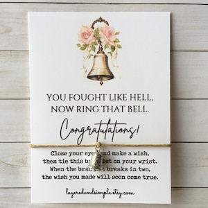 May include: A white card with text and a bell charm bracelet. The card reads "YOU FOUGHT LIKE HELL, NOW RING THAT BELL. Congratulations!" and includes instructions for the bracelet. A gold-colored bell charm hangs from a string.