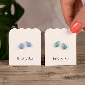 Può includere: Due paia di piccoli orecchini a forma di goccia su carte bianche. Gli orecchini sono blu e turchese. Le carte riportano la scritta "Brlogarka".