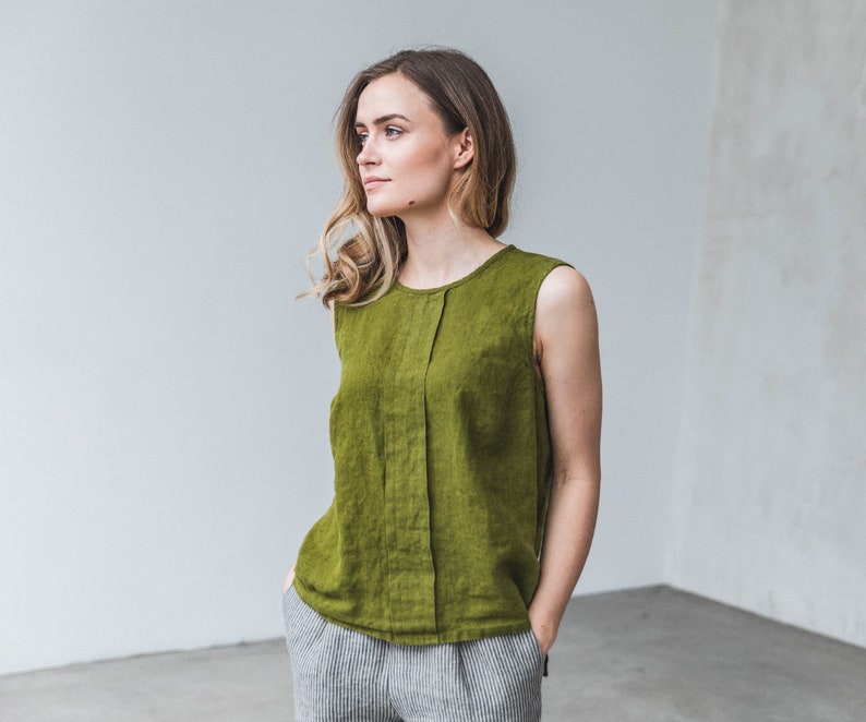 May include: A sleeveless, olive green linen top with a center seam and a round neckline.
