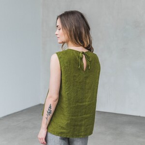 May include: A sleeveless, olive green linen top with a tie at the back.