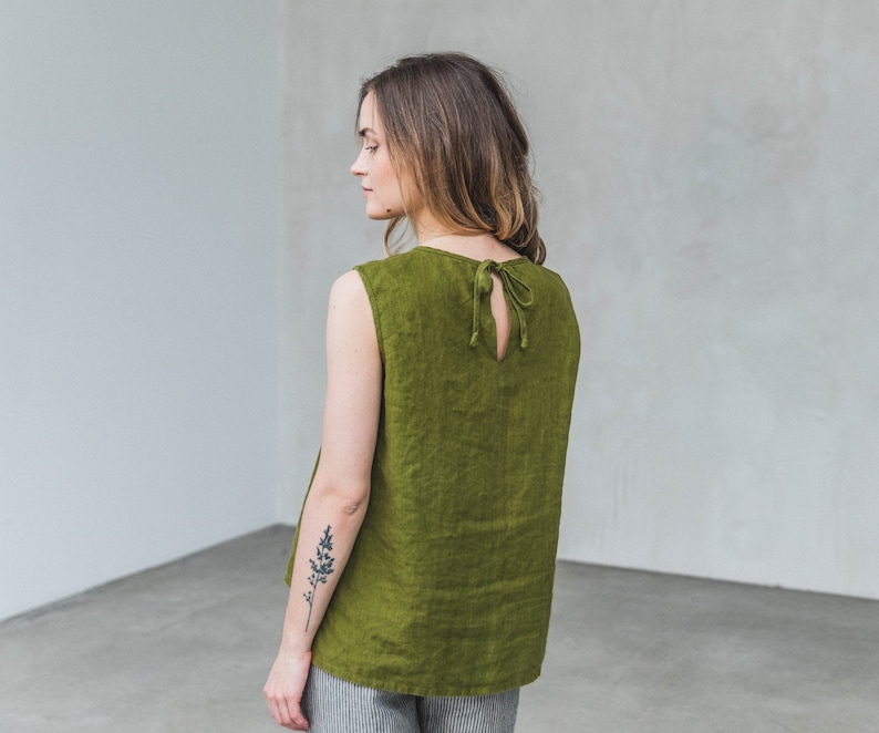 May include: A sleeveless, olive green linen top with a tie at the back.