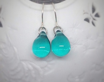 May include: Teal glass teardrop earrings with silver hooks.