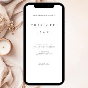以下が含まれることがあります： スマートフォンには、「Charlotte and James」の名前が書かれた結婚式の招待状が表示されています。招待状には日付、時間、場所の詳細が含まれています。電話は、ろうそくとドライフラワーのあるニュートラルな背景にあります。