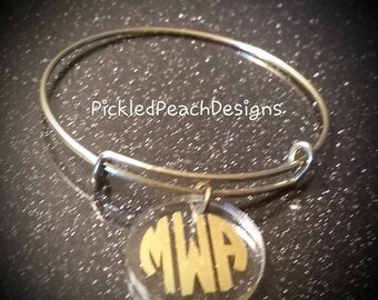Gold tone bangle bracelet with clear disc