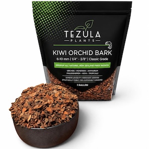 May include: A black bag of Tezula Plants Kiwi Orchid Bark with a green gradient top. The label reads 6-10 mm | 1/4" - 3/8" | Classic Grade, Premium All Natural New Zealand Pinus Radiata, 1 Gallon. A dark bowl filled with brown bark chips sits in front.