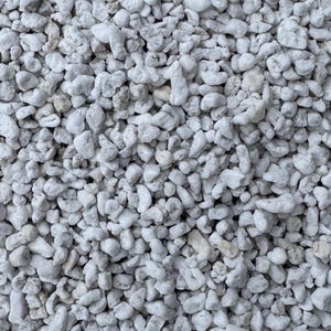 May include: Close-up of a pile of small, white, irregularly shaped stones. The stones are all about the same size and have a rough, textured surface.
