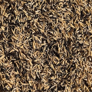 May include: Close-up of a pile of rice husks. The husks are a light tan color, with some darker brown and black specks mixed in. The texture is rough and organic, with many small, sharp edges. The image is well-lit, showing the details of the husks.