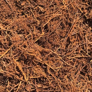 May include: A dense collection of dried, fibrous, reddish-brown organic root material. The texture is tangled and irregular, consisting of numerous thin, woody strands and small, brittle particles that create a complex, layered, and earthy appearance.