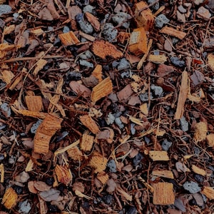 May include: Close-up of a mix of natural mulch, including brown wood chips, dark gray pebbles, and thin, dried twigs. The texture is rough and organic, with varying shades of brown and gray.