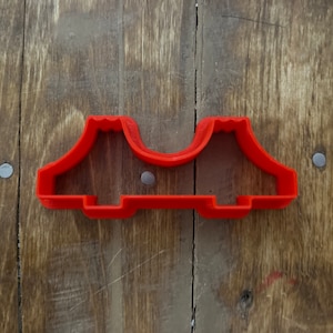 Może przedstawiać: Ciastko wykrawacz w kształcie biustonosza, wykonany z czerwonego plastiku.