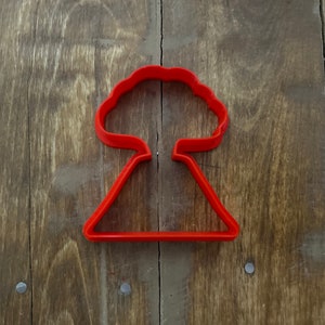 May include: Red plastic cookie cutter shaped like a mushroom cloud.
