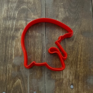 Puede incluir: Cortador de galletas de plástico rojo con forma de casco de fútbol americano.