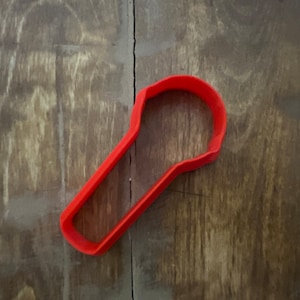 May include: A red plastic cookie cutter shaped like a light bulb.