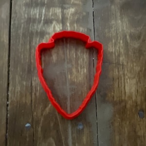 May include: Red plastic cookie cutter shaped like the National Park Service arrowhead logo.