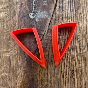 May include: Two orange plastic triangle-shaped cookie cutters.