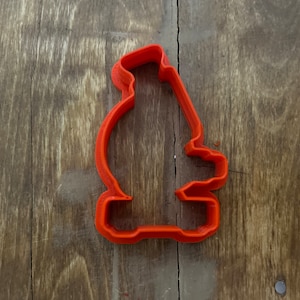 Puede incluir: Un cortador de galletas de plástico rojo con forma de microscopio.