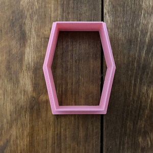 Könnte beinhalten: Ein rosa, sechseckiger Ausstecher aus Kunststoff.