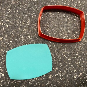 以下が含まれることがあります： 楕円形の赤いプラスチック製のクッキーカッターと、楕円形の薄い青色のプラスチック製のクッキーカッターです。