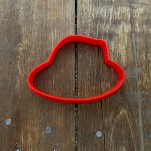 Könnte beinhalten: Roter Plastik-Ausstecher in Form eines Hutes.
