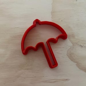 Könnte beinhalten: Roter Plastik-Ausstecher in Form eines Regenschirms.