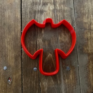 May include: Red plastic cookie cutter shaped like an axe.