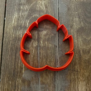 May include: Orange plastic cookie cutter shaped like a leaf.